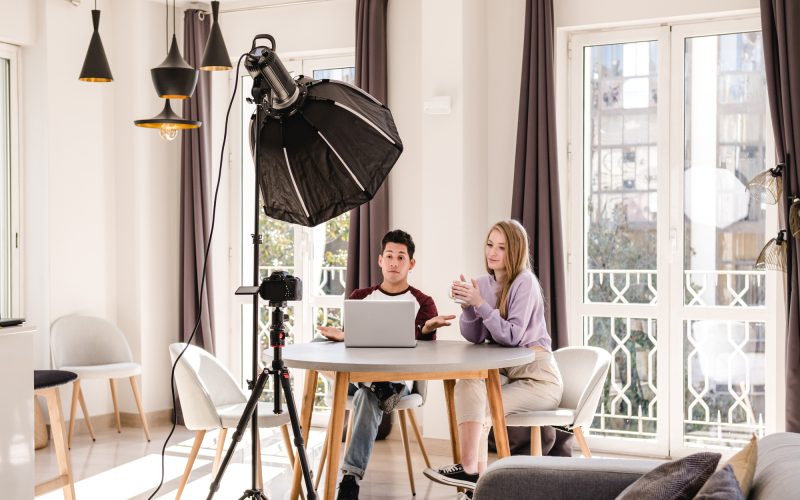 video bloggers making a video with a professional camera on a tripod at home.